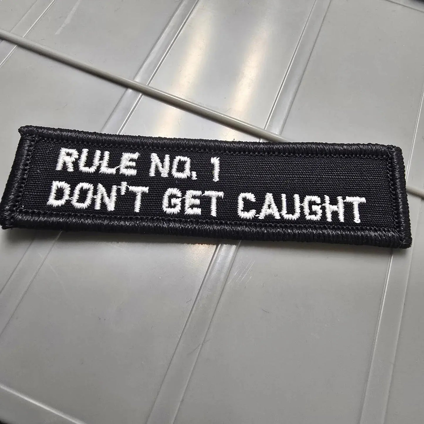 As Seen on Socials - Rule No. 1 - Don't Get Caught - 1x3.75 Patch - Black w/White Tactical Gear Junkie